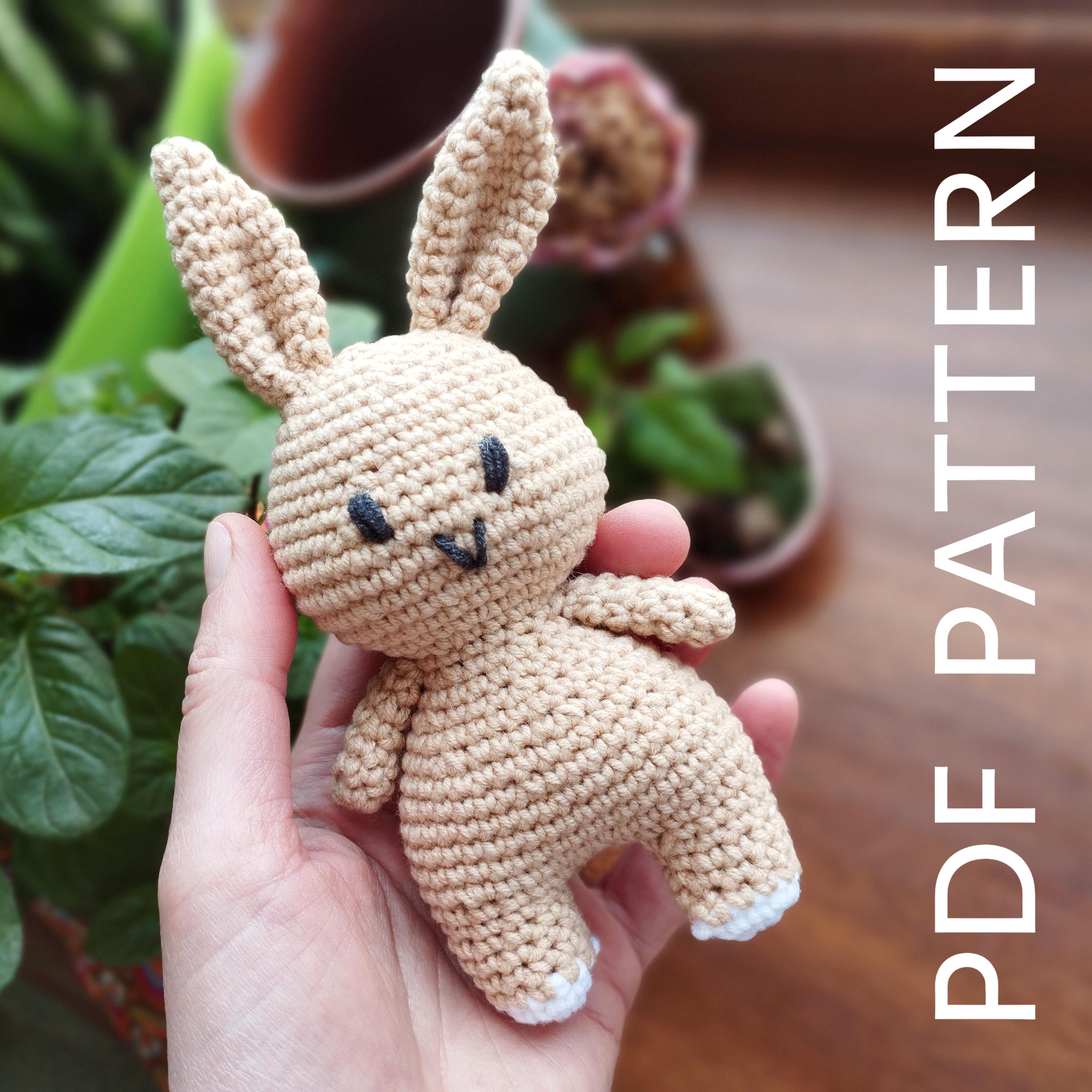 a hand holding a small crocheted stuffed animal